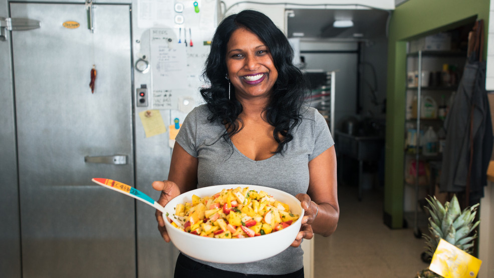 Calypso Kitchen Catering - Founder and Owner Sarah Chan, holding a bowl of Pineapple Chow